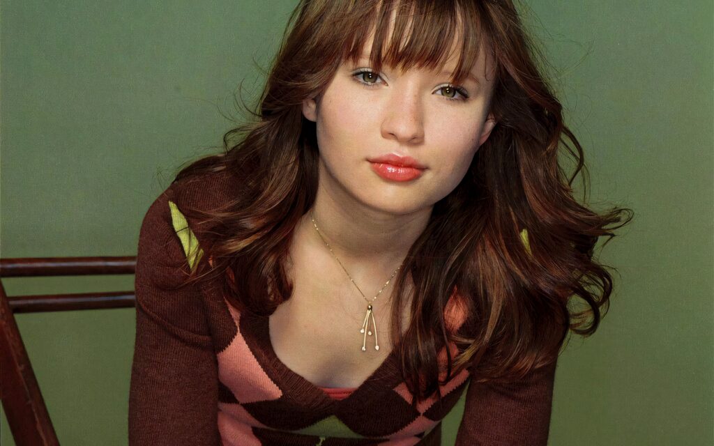 Emily Browning portrait in patterned sweater with natural makeup against muted green backdrop Wallpaper