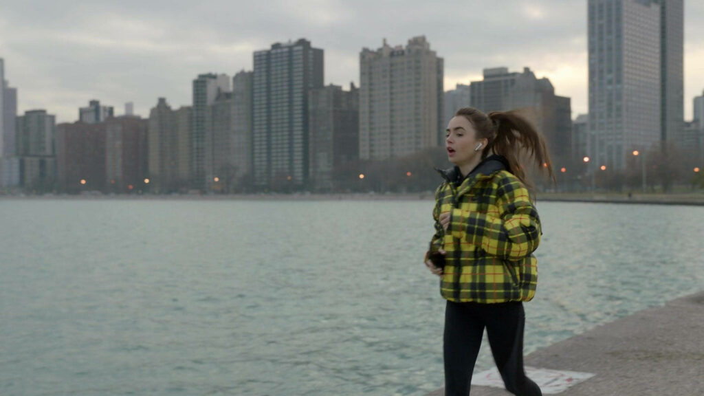 Emily jogging waterfront city skyline stylish energetic scene from Emily In Paris wallpaper background