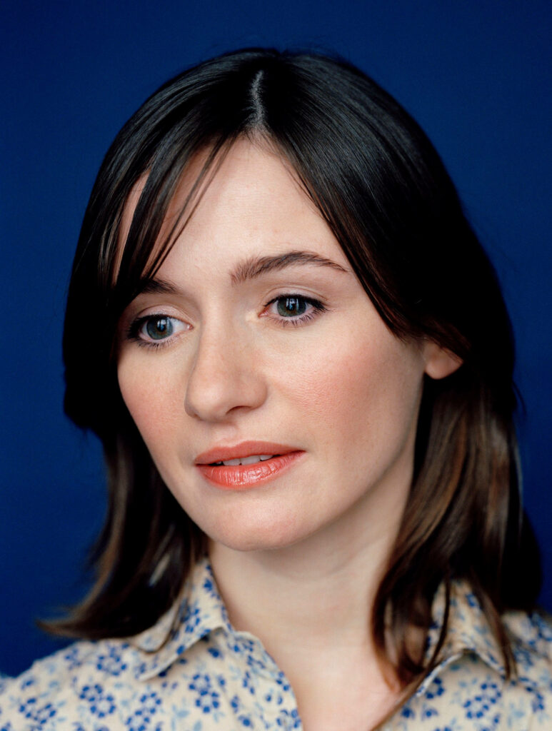 Emily Mortimer close-up portrait soft lighting deep blue background floral blouse serene expression Wallpaper