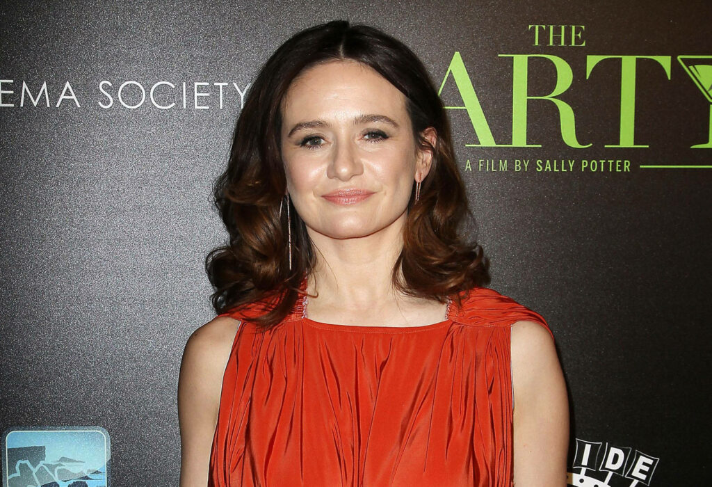 Emily Mortimer in vibrant red dress at film event with dramatic lighting and formal backdrop Wallpaper