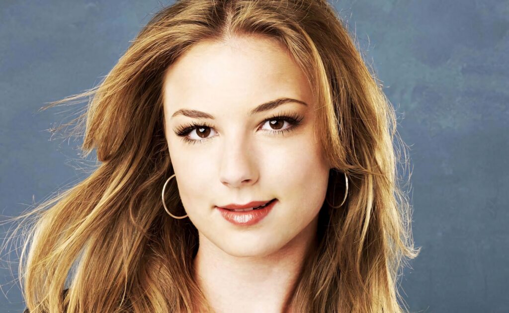 Emily VanCamp close-up portrait with natural makeup and flowing hair on textured blue background Wallpaper
