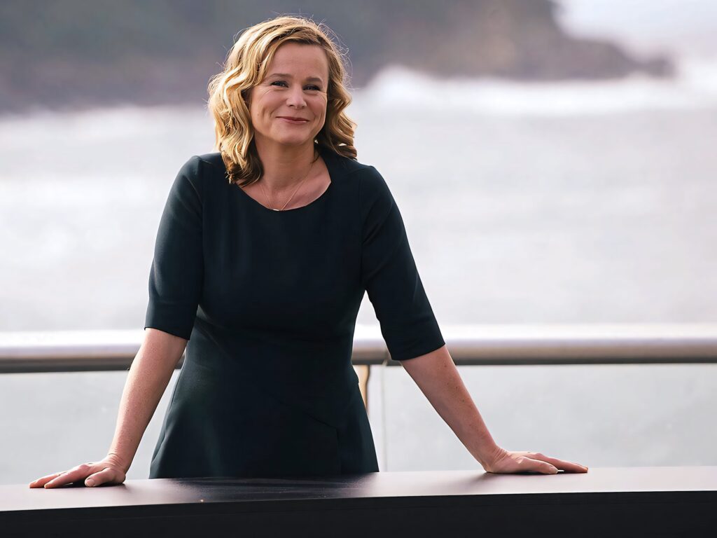 Emily Watson serene by pier coastal backdrop calm elegant portrait wallpaper background