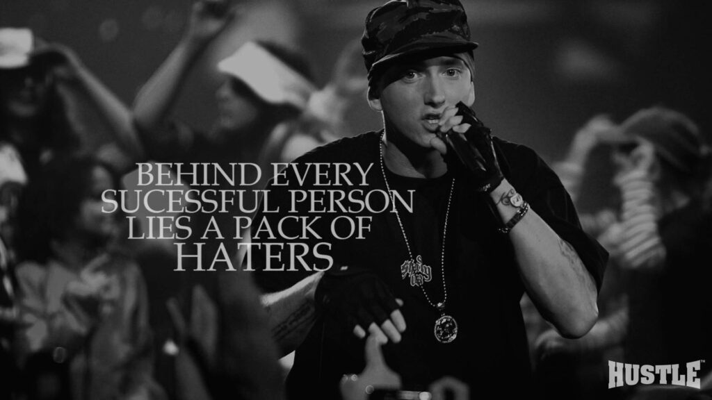 Grayscale Eminem performing on stage with motivational success and critics quote wallpaper background