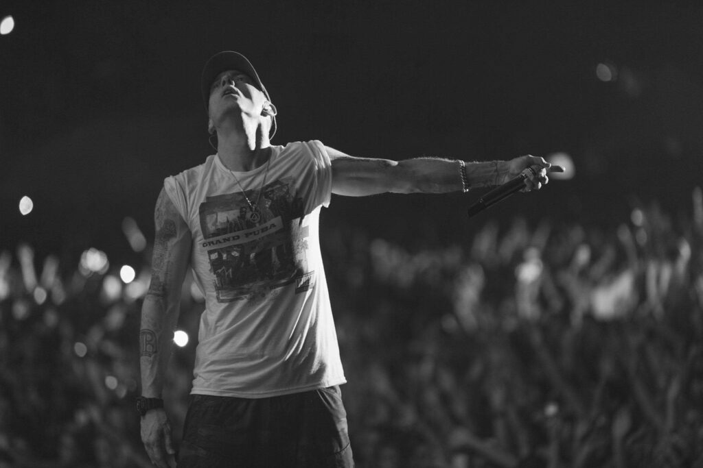 Eminem performing live on stage in white t shirt captivating huge crowd black and white wallpaper