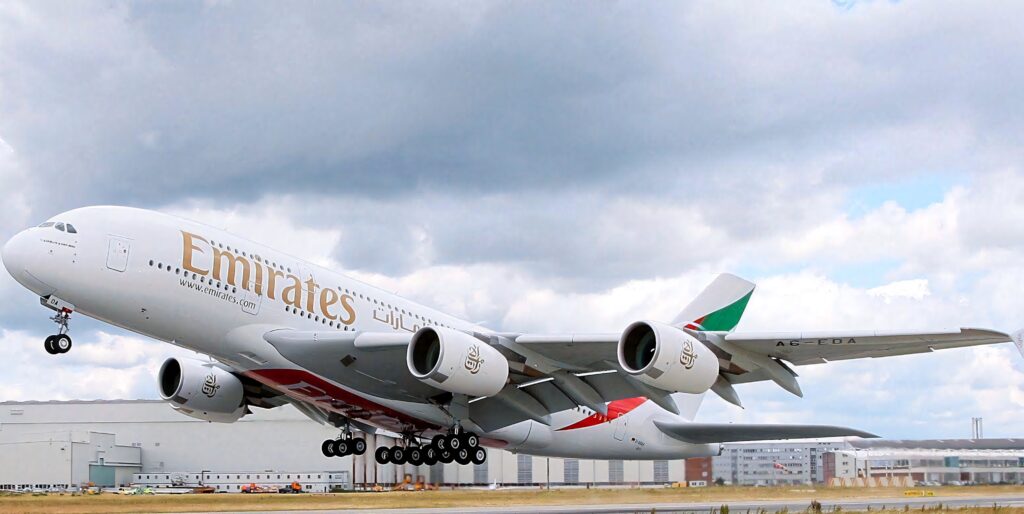 Emirates Airbus A380 soaring with vibrant clouds showcasing modern aviation technology wallpaper