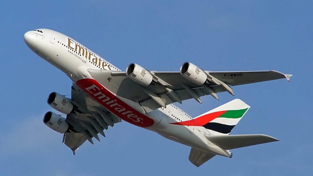 Emirates Airbus A380 in flight with white fuselage red branding UAE flag tail clear blue sky Wallpaper