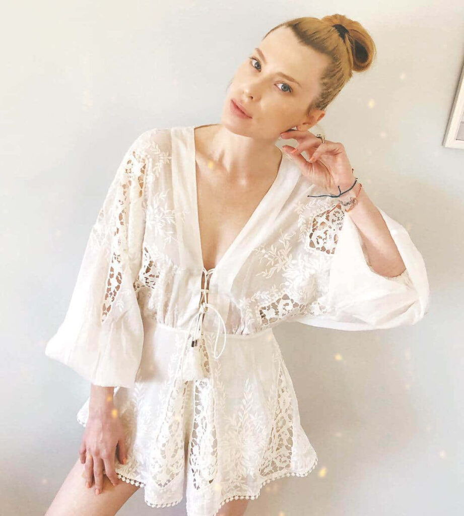 Emma Booth in white lace romper against neutral background with soft lighting and elegant style Wallpaper