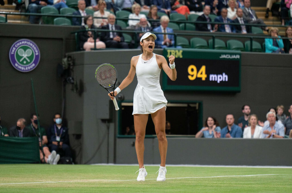 Emma Raducanu in Wimbledon white mid-court intense pose high-stakes tennis match wallpaper