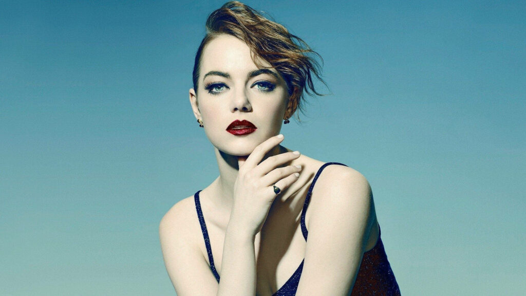 Emma Stone confident glam wallpaper bold red lips intense gaze cool blue background editorial style