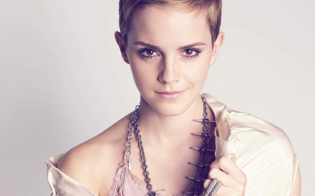Emma Watson with short chic hair and statement necklace on pastel background wallpaper