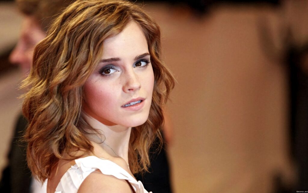 Emma Watson close-up portrait with warm lighting soft background expressive eyes wavy hair Wallpaper