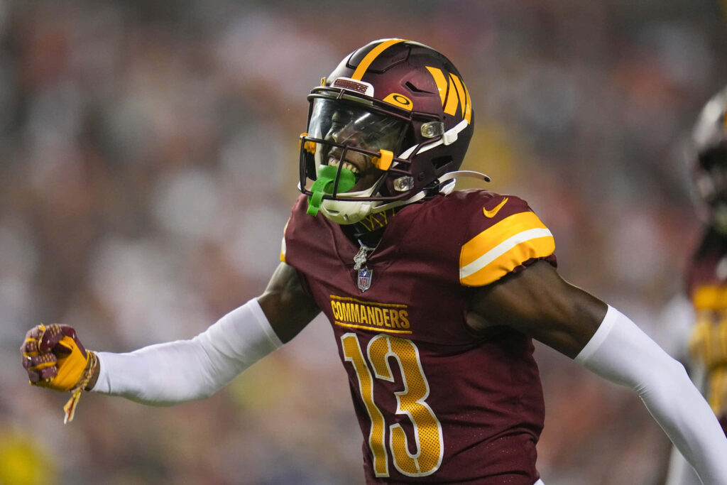 Emmanuel Forbes Jr in burgundy and gold Commanders uniform showing intensity during NFL game Wallpaper