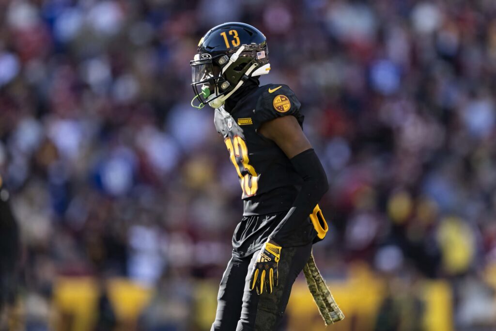 Emmanuel Forbes Jr in black and gold football uniform focused mid-action on the field wallpaper