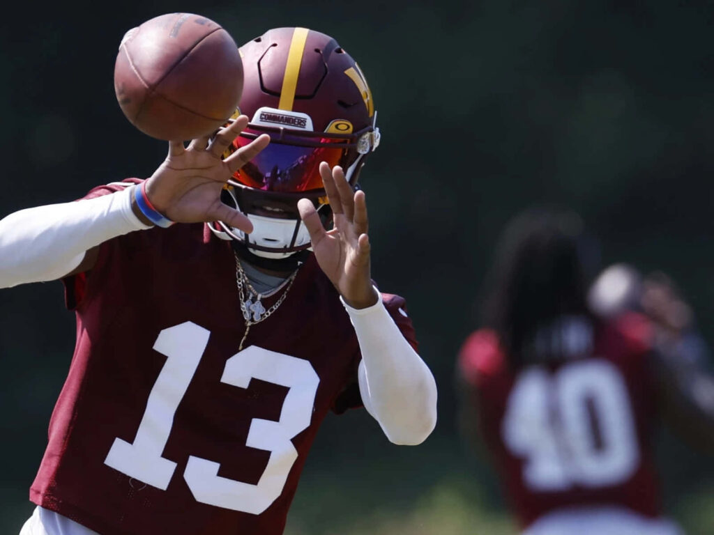 Emmanuel Forbes Jr catching football mid-action in maroon jersey during intense practice session Wallpaper