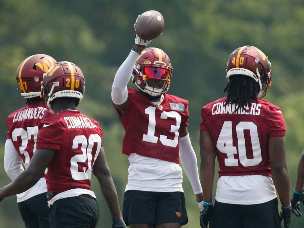Emmanuel Forbes Jr in number 13 jersey holding football during practice with teammates in burgundy and gold Wallpaper