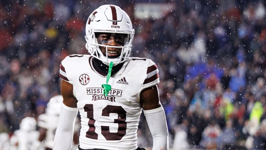 Emmanuel Forbes Jr. focused in maroon and white uniform during rainy intense Mississippi State football game Wallpaper