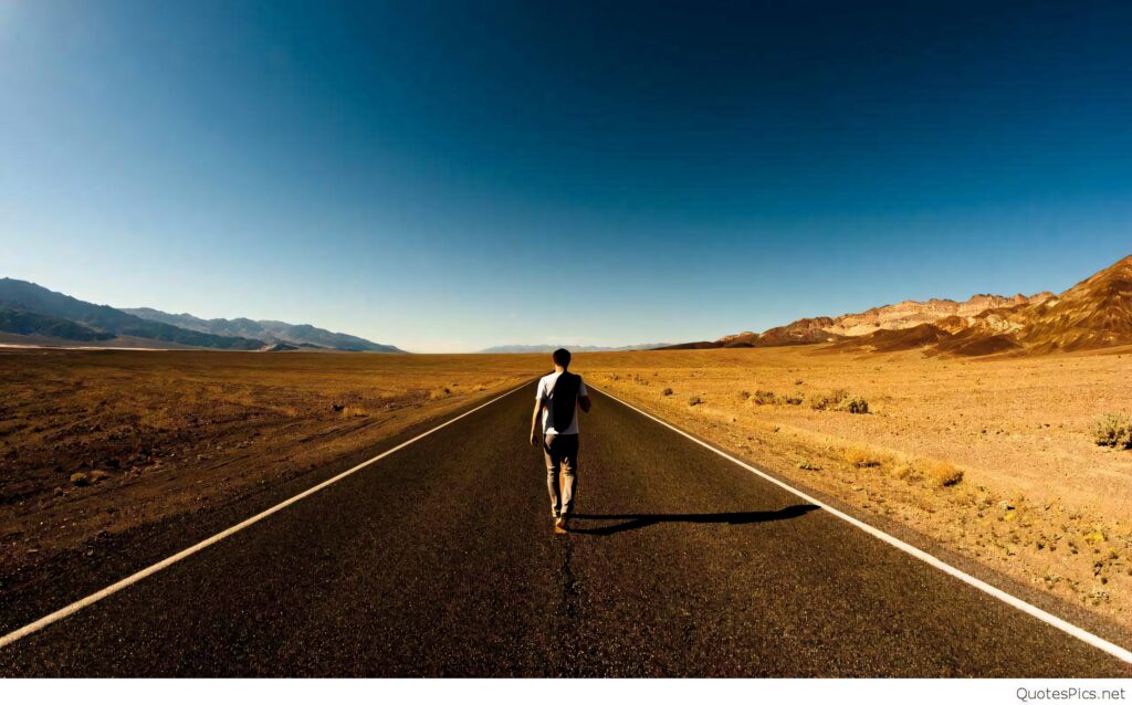 Solitary figure walks empty desert road under deep blue sky emo aesthetic loneliness wallpaper background