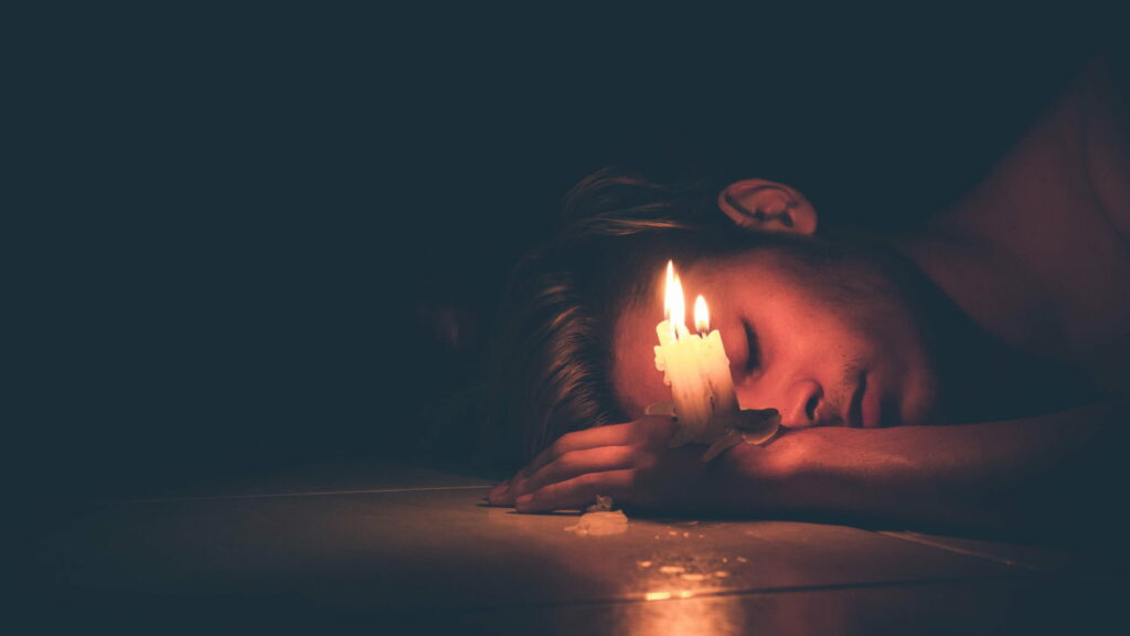 Lonely Vigil: HD Wallpaper of a Sad Man Holding Candles, Battling Depression