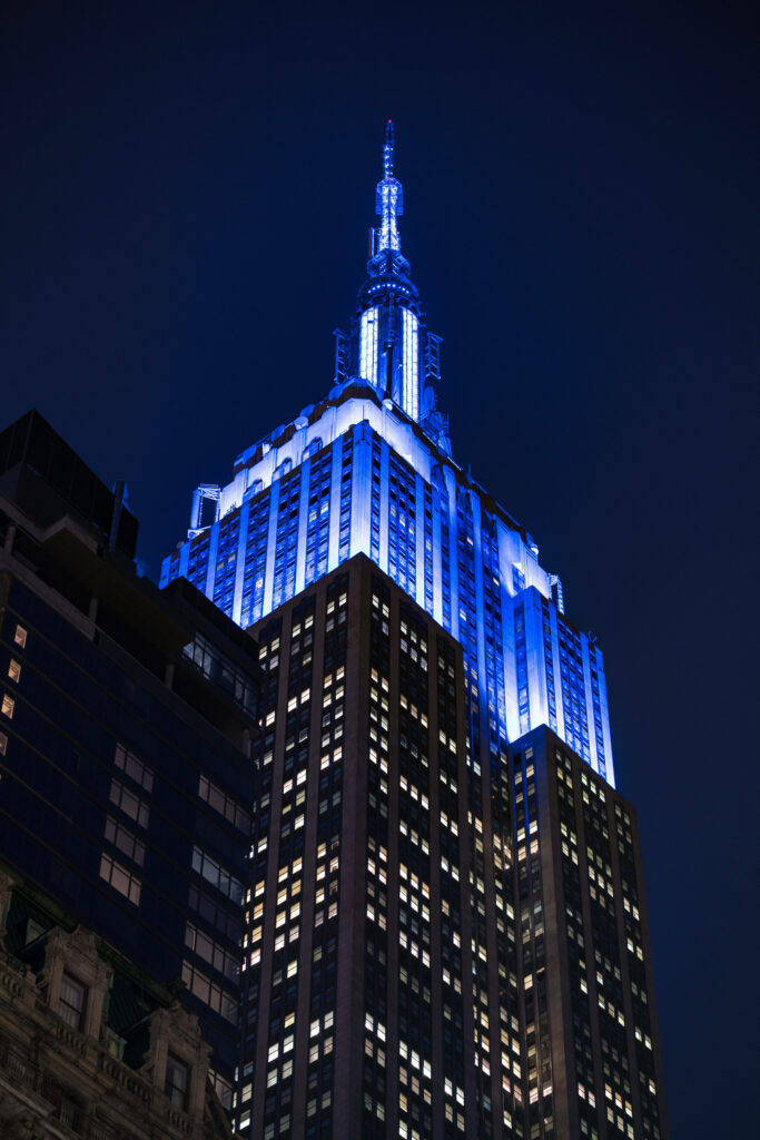 Captivating Nighttime Glow: Empire State Building Shining Radiant Blue in Soothing Dark Sky Wallpaper