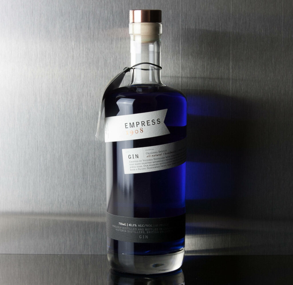 Empress 1908 Gin 750ml bottle with indigo-blue gin on sleek metallic background wallpaper