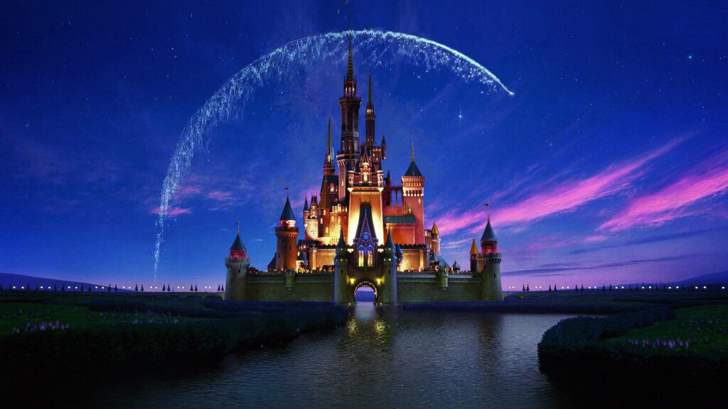 Magical Disney Castle glowing at twilight with sparkling fairy dust over shimmering water background Wallpaper