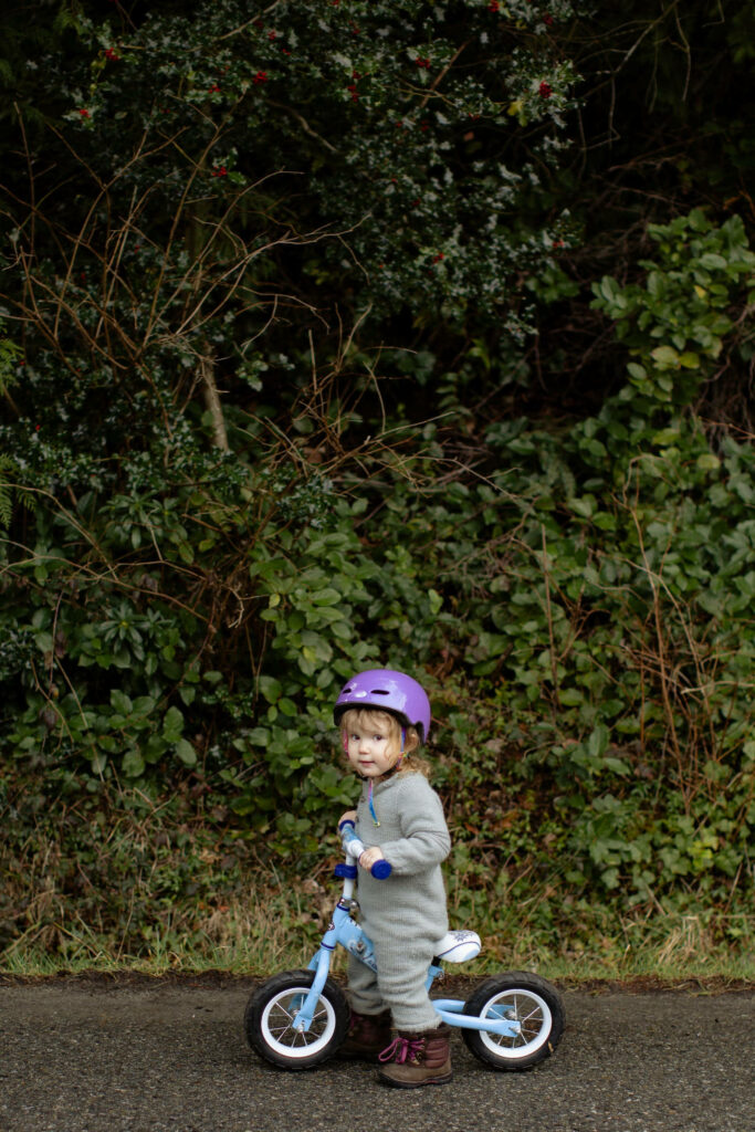 Enchanting Little Adventurer Pedals Her Way Into Our Hearts Amidst Serene Greenery Wallpaper