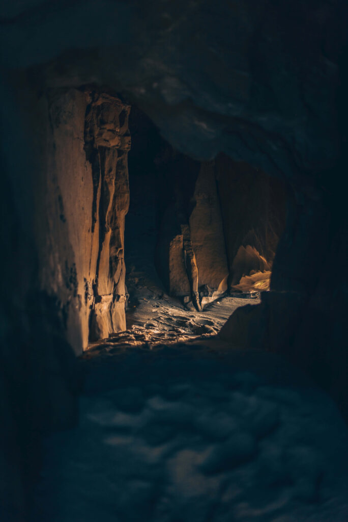 Illuminated Cave Interior: Textured Rock Walls in Amber Light Wallpaper