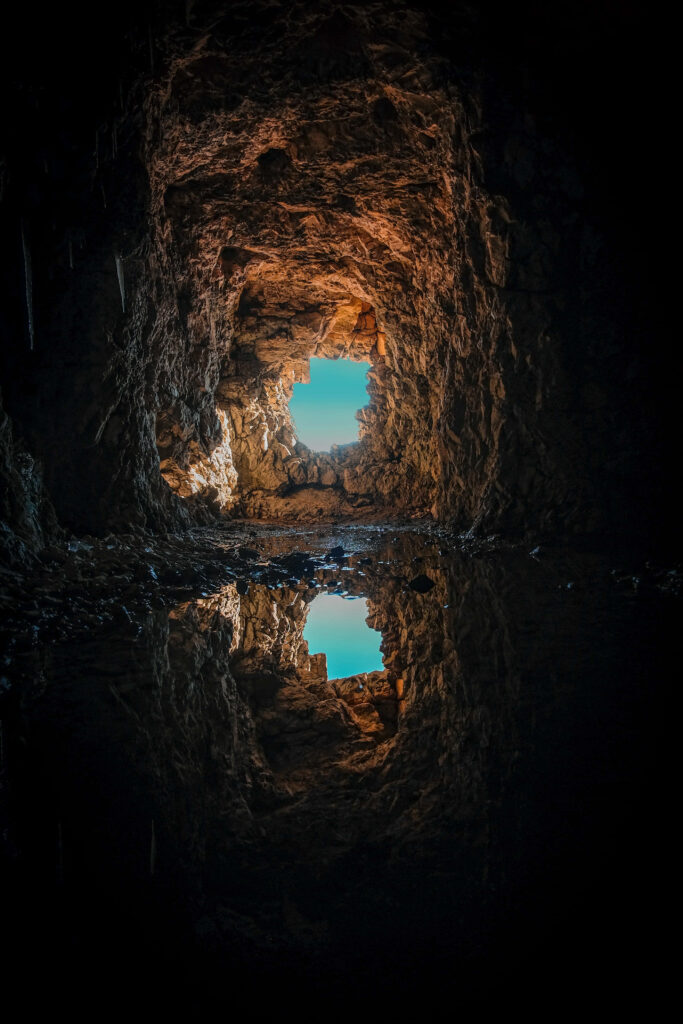 Enchanting Cave Wallpaper: Rugged Rocks & Mystical Reflections