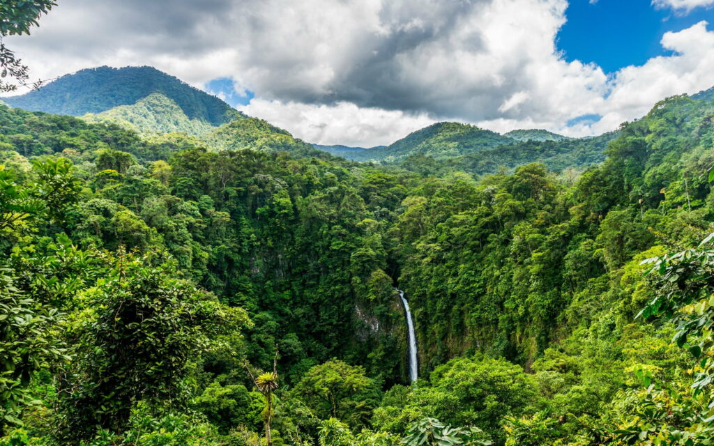 Enchanting Costa Rican Paradise: Majestic Waterfall amid Lush Tropical Jungles and Picturesque Mountain Peaks - QHD Wallpaper