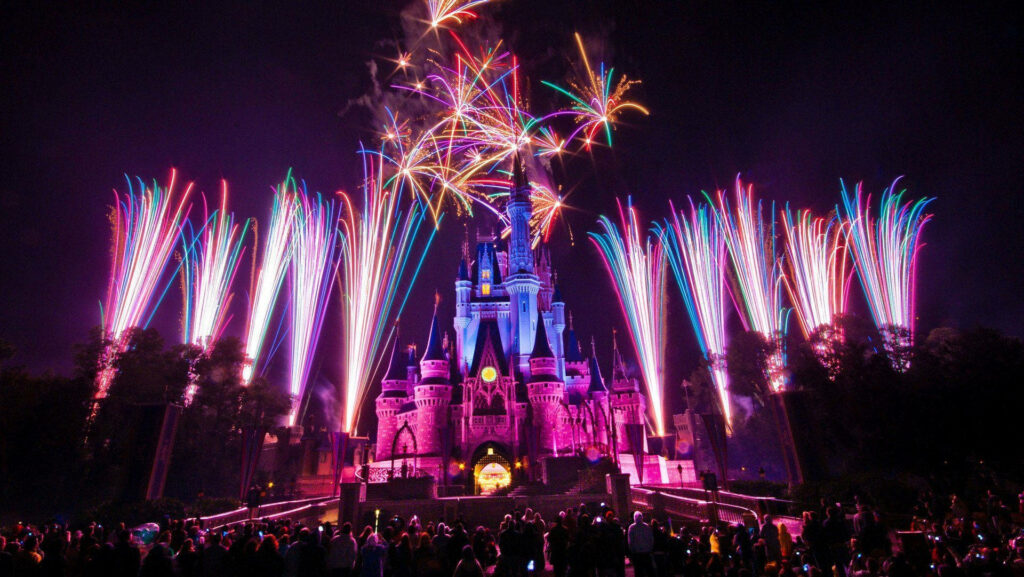 Mesmerized Crowd Gazes at Dazzling Illumination: A Captivating Disney Castle Show Wallpaper
