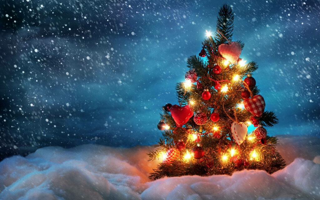 Winter Wonderland Delight: Serene Snowy Night Embellished with a Glowing, Mesmerizing Christmas Tree Wallpaper