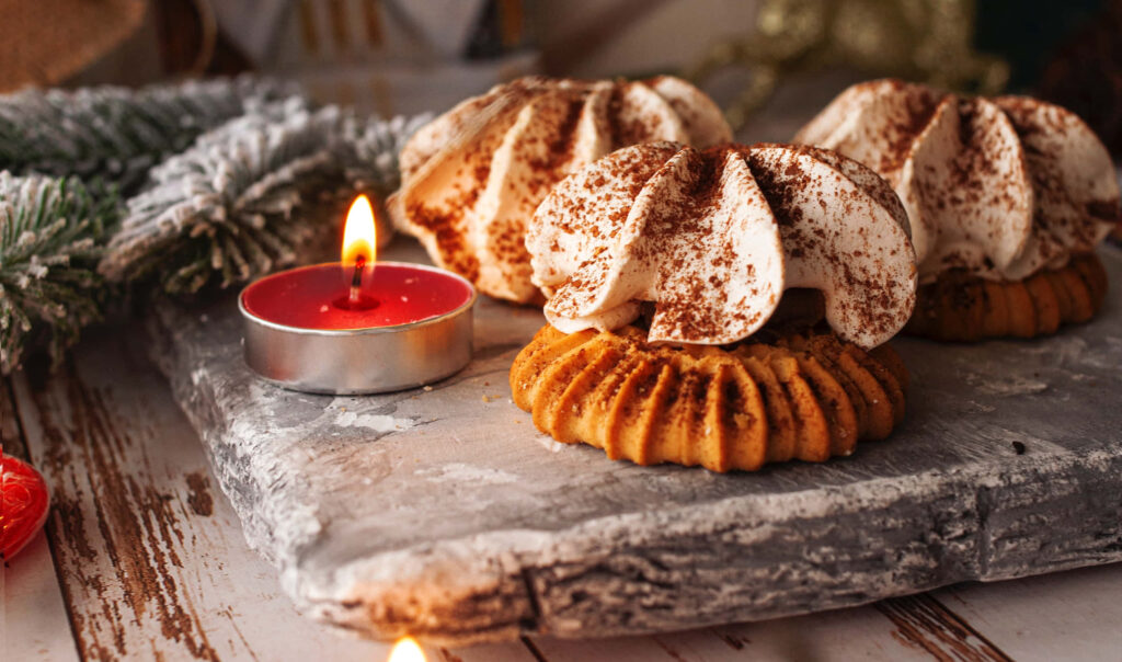 A Festive Candlelight Treat: Glistening Iced Cookies Amidst a Crumbly Delight Wallpaper