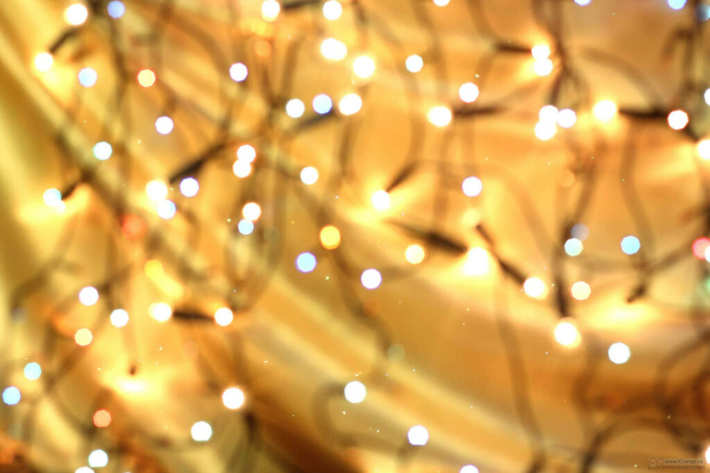 Enchanting Holiday Wallpaper: Glowing String Lights on Golden Background