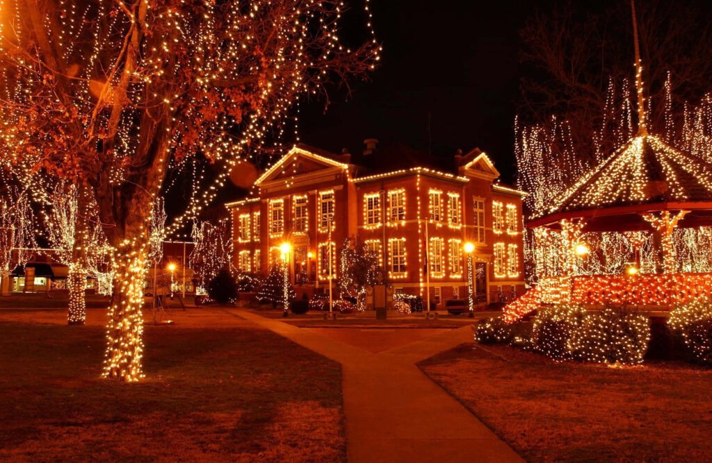 Enchanting Winter Wonderland: Historic Building with Dazzling Lights Wallpaper