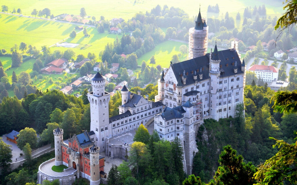 Fairytale Neuschwanstein Castle Wallpaper Amidst Lush Green Forests