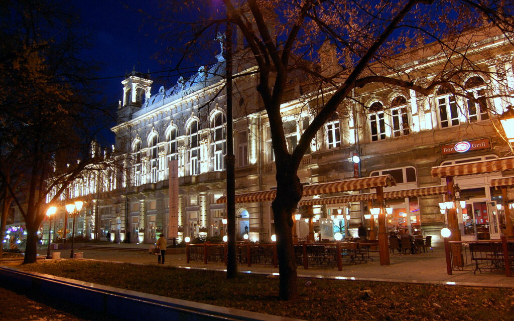 Night view of Ruse Bulgaria with illuminated historic buildings and cozy cafes wallpaper background