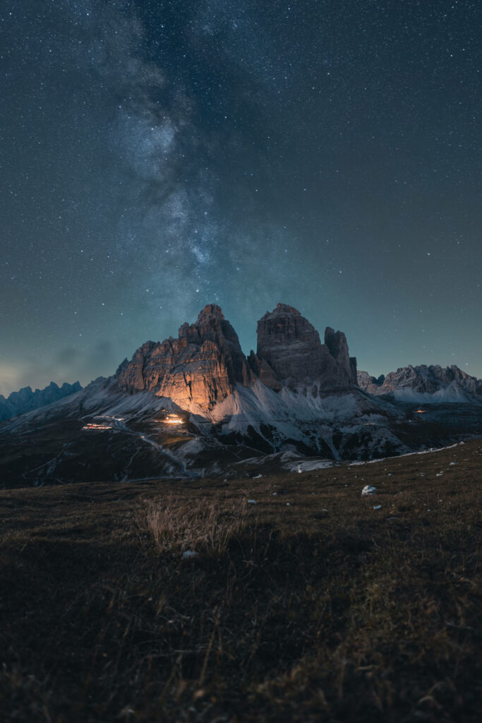 Majestic Nighttime Mountainscape: Celestial Splendor amidst Serene Glow Wallpaper