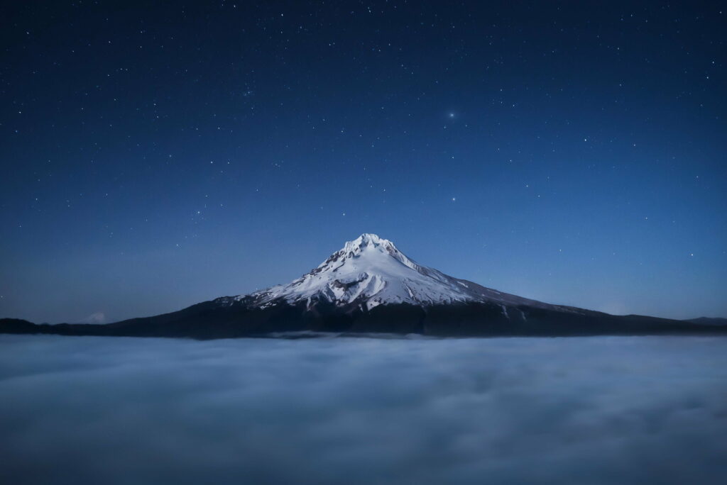 Majestic Nighttime View: Mount Hood Emerging Above the Mesmerizing Cloud Cover Wallpaper