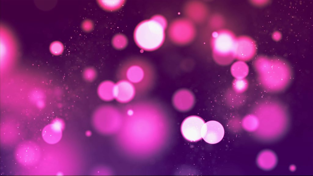 Purple bokeh background with glowing pink light orbs and sparkling particles festive wallpaper