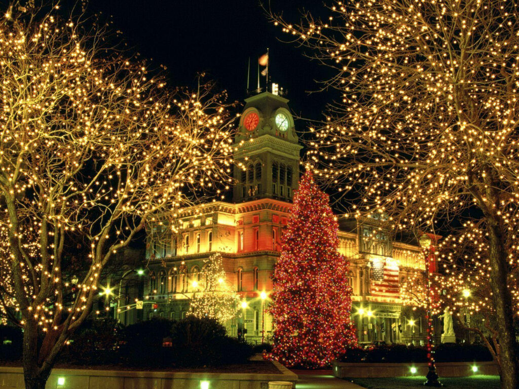 A Serene Winter Wonderland: Glowing Trees and Illuminated Architecture Shine in this Lovely Christmas Celebration Wallpaper