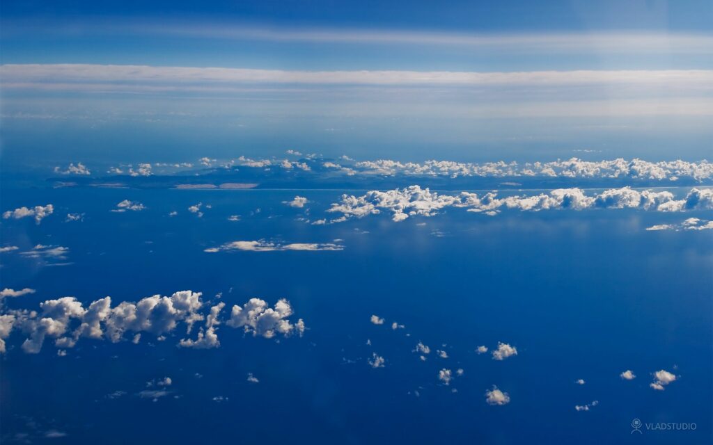 Aerial view of blue sky with white clouds over deep blue ocean serene natural wallpaper background