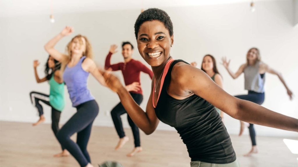 Diverse group dancing joyfully in bright modern studio vibrant energetic dance practice wallpaper