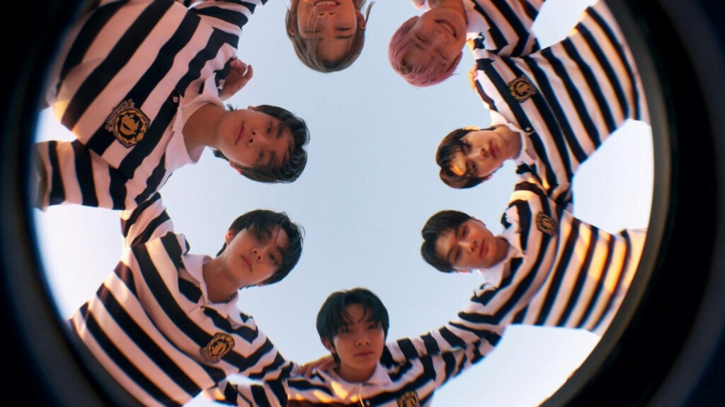 Enhypen members huddle in playful fisheye lens photo with clear sky wallpaper background