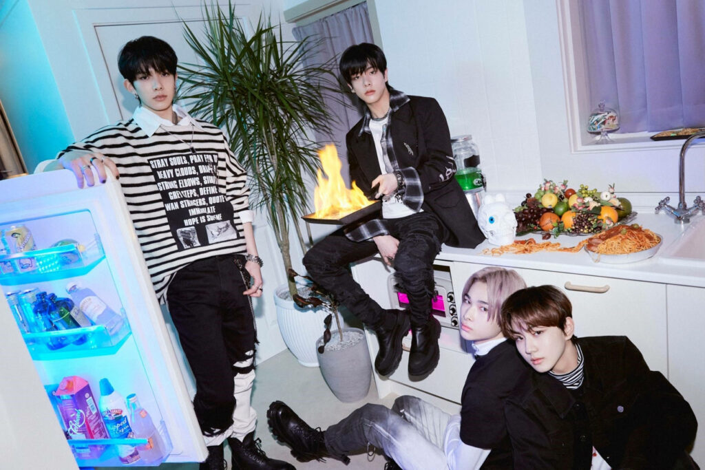 Enhypen members in vibrant kitchen scene with flaming pan and stylish Hype Border Carnival look wallpaper