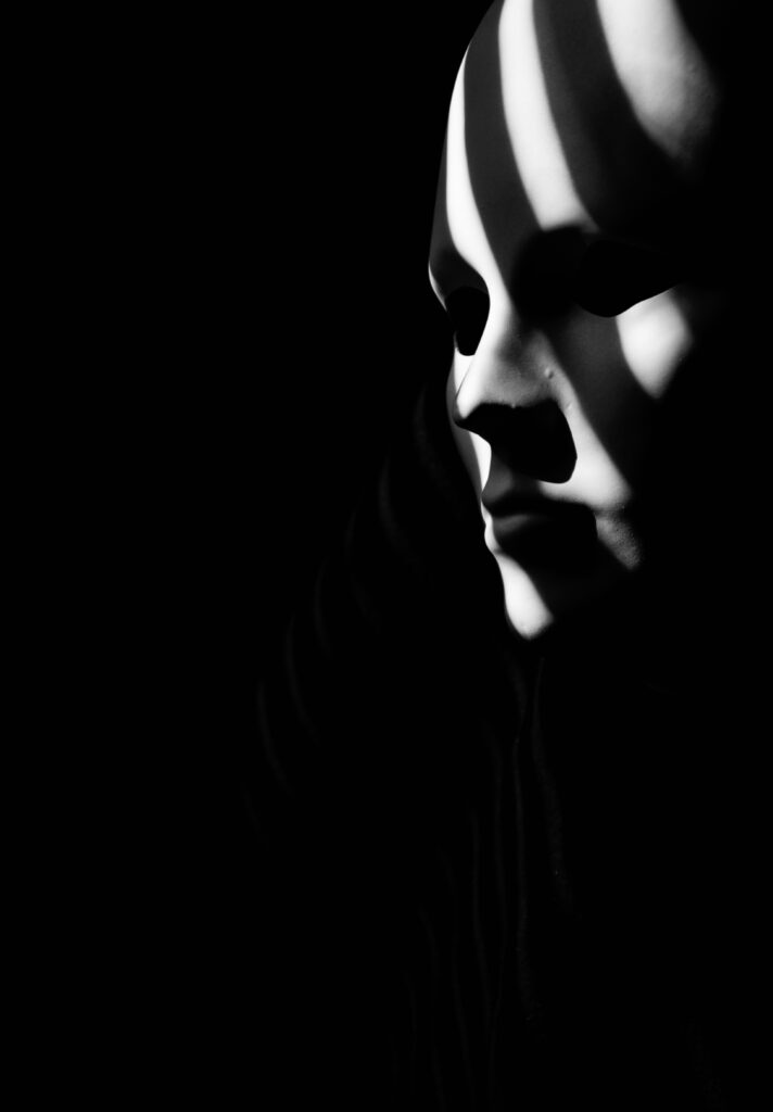 Enigmatic Black & White Wallpaper with Mysterious Mask in Shadows