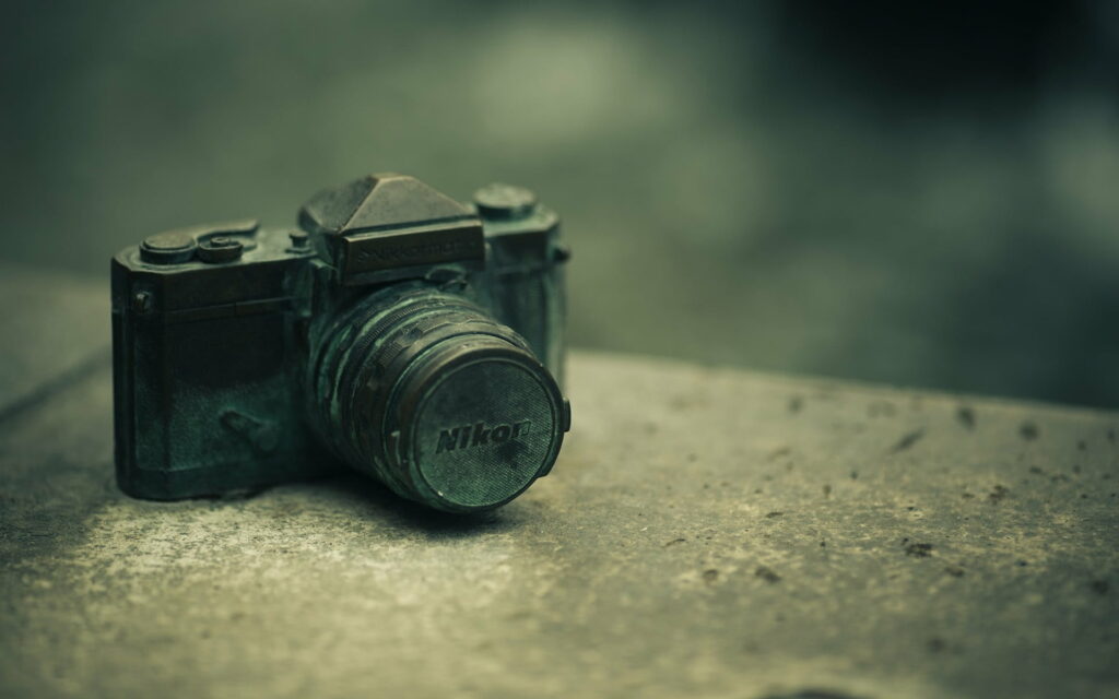Blurred Moments: Immersed in Technological Serenity - A Captivating HD Wallpaper featuring a Selective Focus on a Black Nikon DSLR Camera