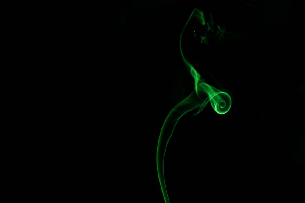 Mystical Hues Amidst the Shadows: Vibrant Green Colored Smoke HD Wallpaper