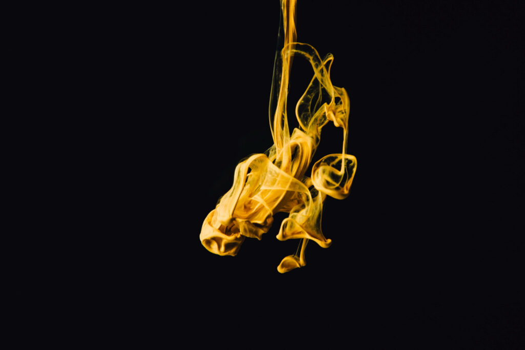 Captivating Yellow Substance Swirling on Dark Background Wallpaper