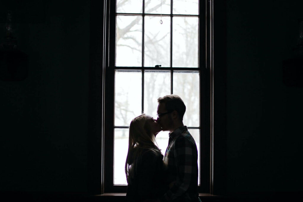 On the Wings of Love: Envious Hearts Admire the Silhouetted Passion by a Wide Window Wallpaper
