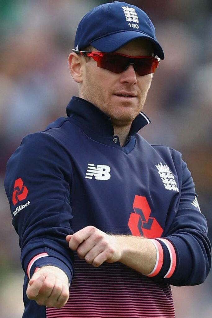 Eoin Morgan in England cricket jersey rolling up sleeves focused ready energetic blue red tones wallpaper